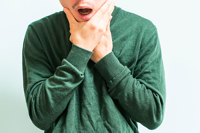 顎を押さえる男性